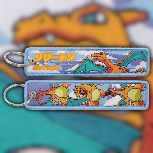 Charizard fiery orange and teal woven fabric keytag attached to metal keyring featuring embroidered Charizard artwork