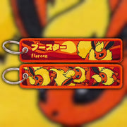 Flareon fiery orange woven fabric keytag attached to metal keyring featuring embroidered Flareon artwork