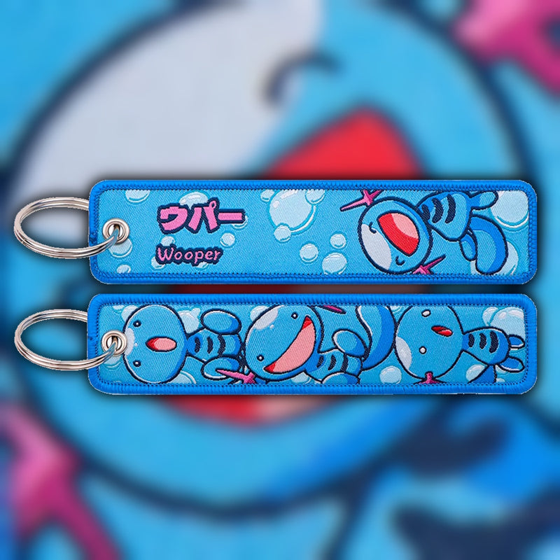 Wooper blue woven fabric keytag attached to metal keyring featuring embroidered Wooper artwork